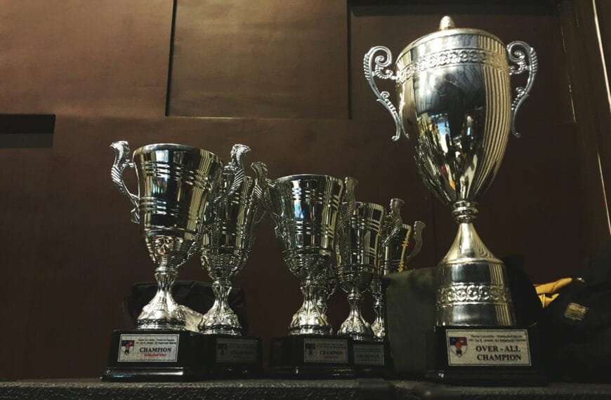 several silver and gold trophies on wooden surface