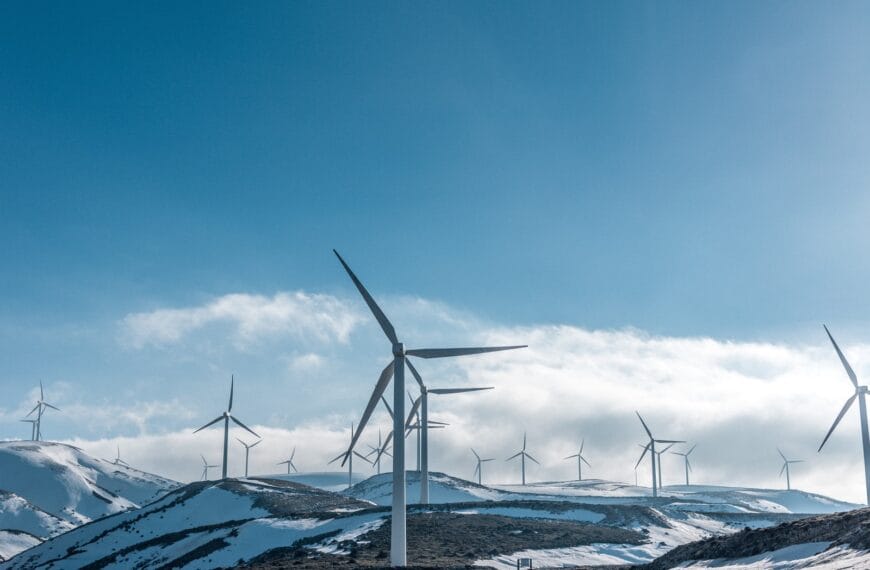 wind turbines on snowy mountain under clear blue sky during daytime