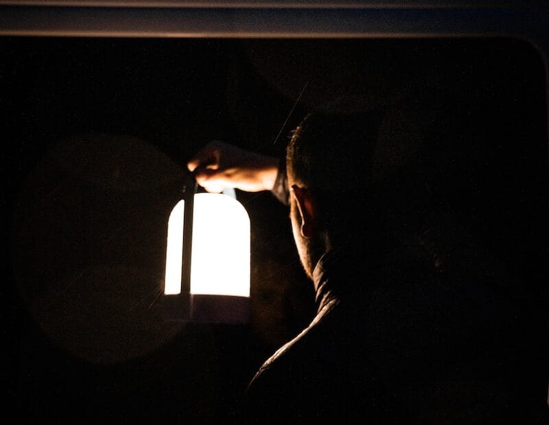 man in black jacket holding light