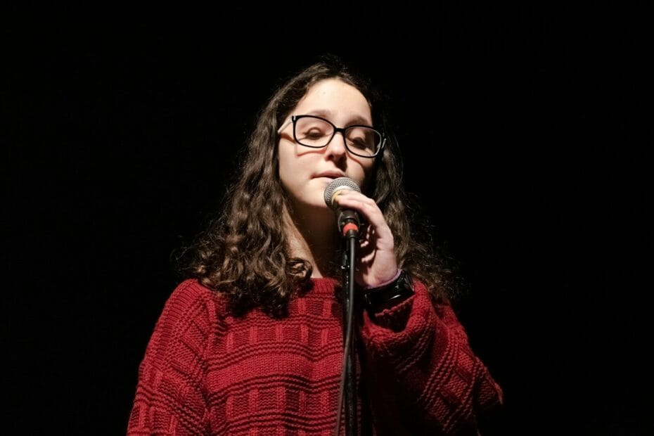 woman in red and black plaid dress shirt singing